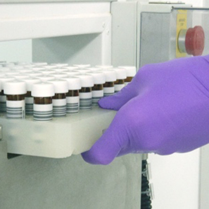 Lab technician pulling racked vials from a storage