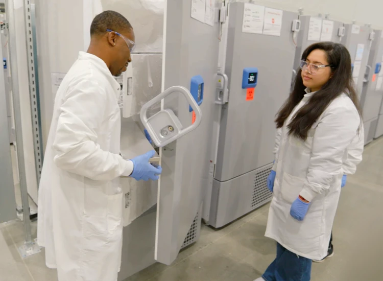 Lab staff interacting in front of freezer