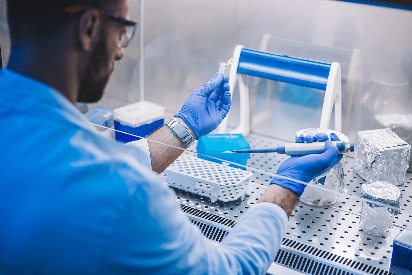 Scientist with microcentrifuge tube and pipette