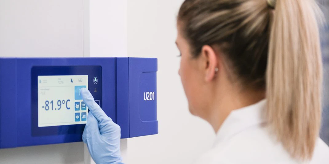 Lab technician setting the temperature to a storage unit