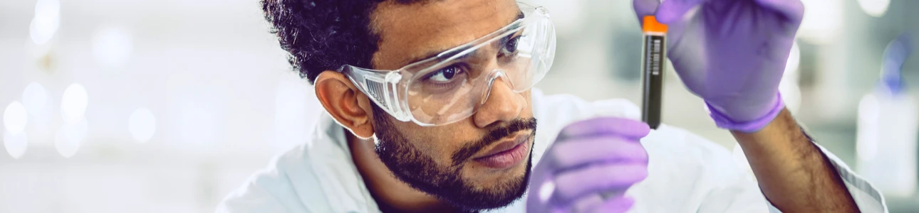 Lab technician inspecting a sample storage tube
